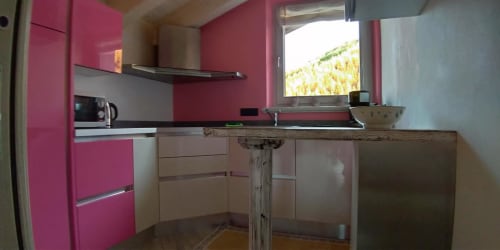 Moderna cucina rosa all'hotel Al Dos di Livigno con mobili contemporanei e vista sulla montagna