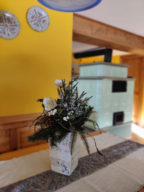 Composizione floreale con fiori bianchi e verdure in vaso decorativo presso l'hotel Al Dos a Livigno