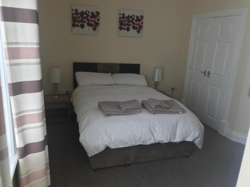 Modern bedroom at The Ball Alley B&B in Stanley, County Durham with double bed and striped curtains