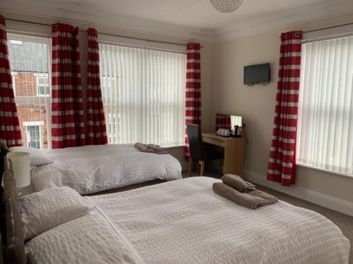 Twin bedroom at The Ball Alley B&B in Stanley, County Durham with red striped curtains and en-suite