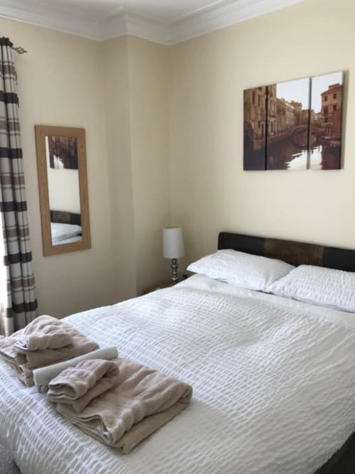 Bedroom at The Ball Alley B&B in Stanley, Durham with double bed, Venice canal artwork, mirror, and folded towels