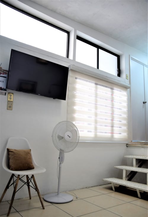 Luminosa habitación en LLUNA, Oaxaca, con TV mural, ventilador, silla moderna y luz natural de las ventanas