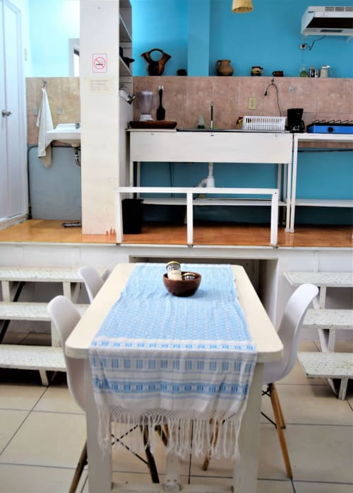 Cocina del departamento LLUNA en Oaxaca con paredes azules, mesa de comedor y decoración tradicional