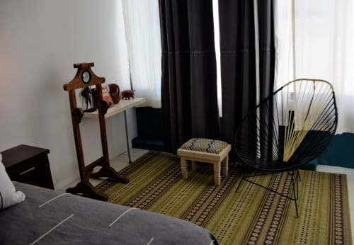 Dormitorio moderno en LLUNA, Oaxaca, con decoración contemporánea: silla negra, muebles de madera y detalles geométricos