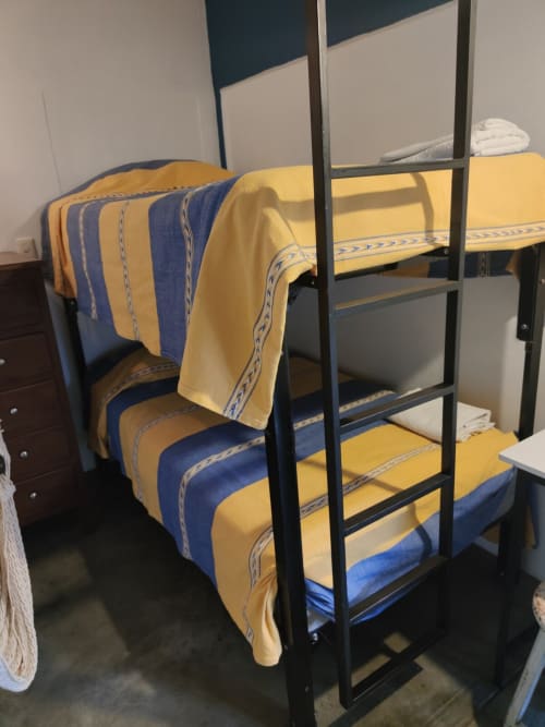 Literas con ropa de cama a rayas azules y amarillas en el departamento LLUNA en Oaxaca de Juárez, México