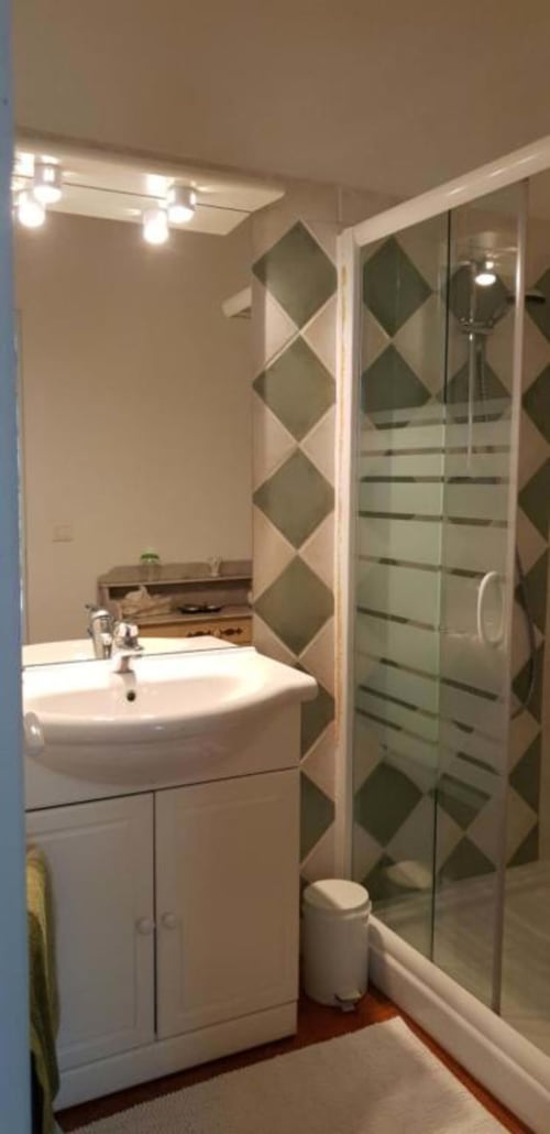 Salle de bains moderne de La Cordeline B&B Brignoles avec lavabo blanc, douche vitrée et mur d'accent en carrelage losangé
