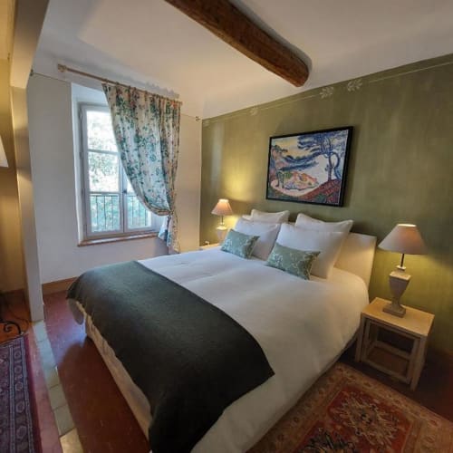 Chambre douillette à La Cordeline B&B à Brignoles : murs verts, lit queen-size, poutre apparente, vue sur la ville