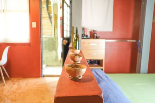 Apartamento LLUNA en Oaxaca con vibrante interior en naranja y azul, cuencos de madera en bancos