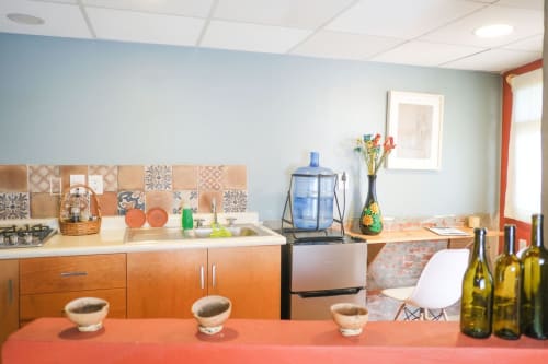Moderna cocina del apartamento LLUNA en Oaxaca con gabinetes naranjas, azulejos patterned en backsplash y decoración colorida.