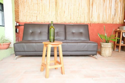 Moderna sala de estar del apartamento LLUNA en Oaxaca con sofá de cuero gris, taburete de madera y decoración con plantas