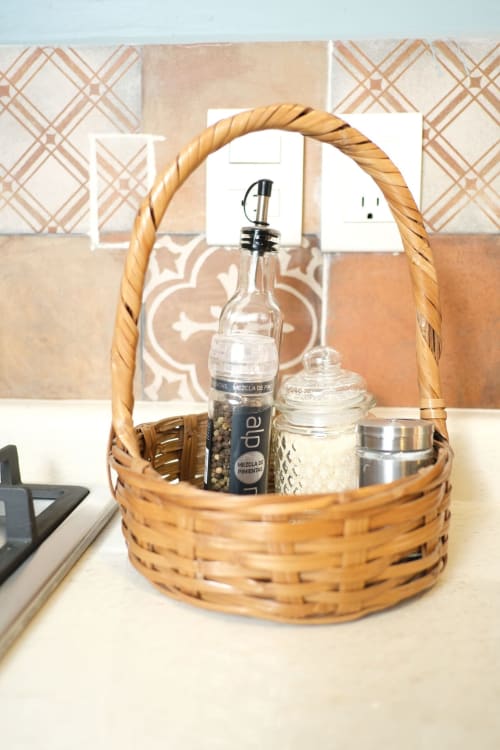 Cesta tejida con botellas de mezcal oaxaqueño y jarra decorativa en apartamento LLUNA, Oaxaca de Juárez