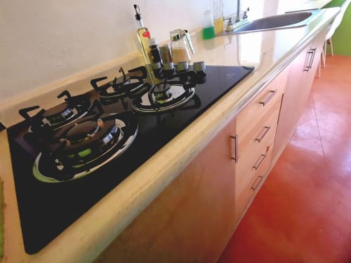 Moderna encimera de cocina con estufa de gas, dispensador de aceite de oliva y botellas de condimentos en el departamento LLUNA, Oaxaca de Juárez