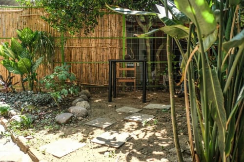 Jardín del apartamento LLUNA en Oaxaca con exuberante vegetación tropical, cerca de bambú y sendero de piedras hacia patio cubierto