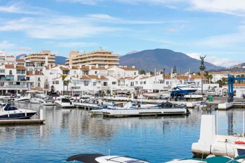 Puerto Banús marina in Marbella with white waterfront apartments, boats, and mountain views
