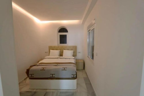 Modern bedroom in First Line Apartment at Marbella Home Rentals, Puerto Banús with double bed and ambient ceiling lighting
