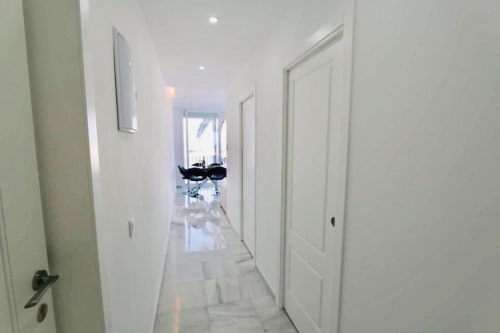 Modern hallway in First Line Apartment, Puerto Banús Marbella with white doors and minimalist design
