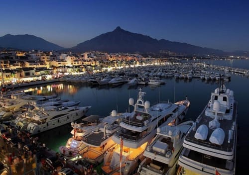 Luxury boats moored at Puerto Banús marina in Marbella with mountain views and waterfront apartments