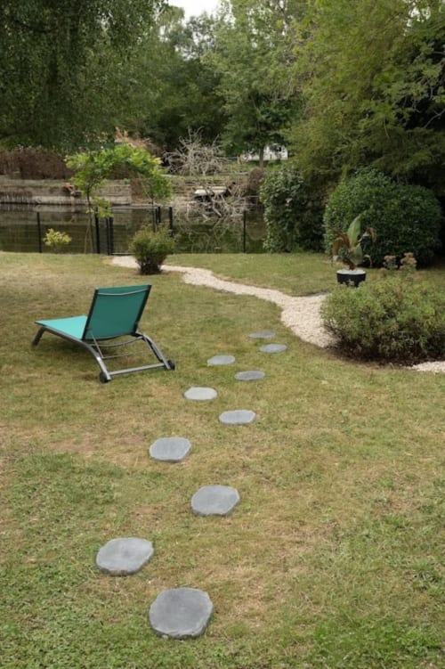 Jardin cottage riverside d'Accolade Châteaudun avec pas japonais, chaise longue et vue sur la rivière