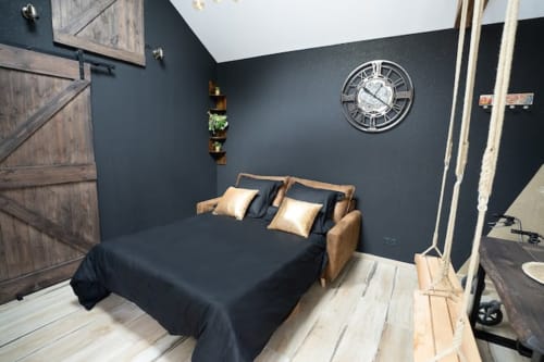 Chambre de la Maison Accolade à Châteaudun : murs bleu-gris, lit en bois, décoration murale avec horloge vue rivière