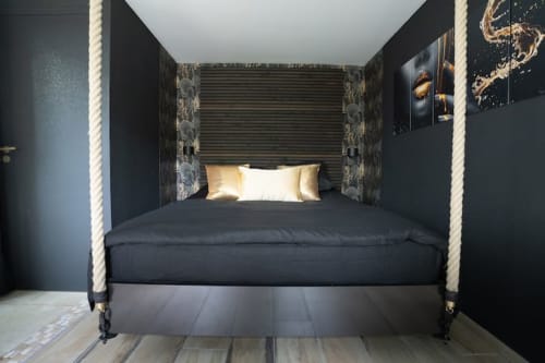 Lit à quatre colonnes avec cadre en corde et literie noire au cottage-hôtel Accolade à Châteaudun, France