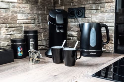 Ensemble de cafetière moderne noire avec bouilloire et tasses au gîte Accolade à Châteaudun