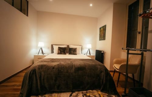 Chambre Accolade à Châteaudun avec lit queen-size, éclairage chaleureux, parquet et vue sur la ville