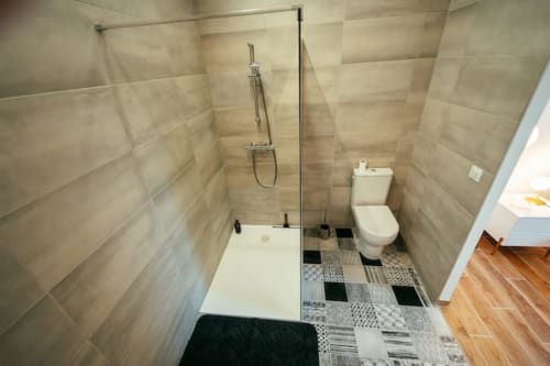 Salle de bain moderne du gîte Accolade à Châteaudun avec douche à l'italienne, toilettes et carrelage motifs