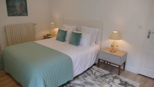 Chambre Accolade à Châteaudun avec lit queen-size, accents verts, tables de nuit et tapis en marbre