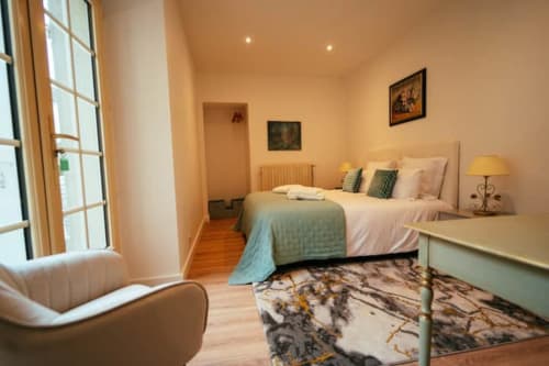 Chambre de l'appartement Accolade à Châteaudun avec lit queen-size, mobilier moderne et grande fenêtre