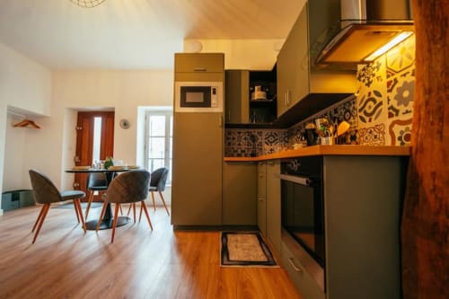 Cuisine et salle à manger modernes de l'appartement Accolade à Châteaudun avec sol en bois et dosseret à motifs