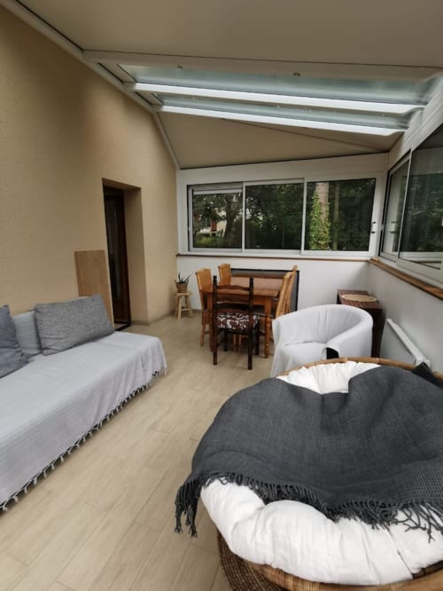 Séjour lumineux à Accolade avec verrière, vue sur le jardin, mobilier confortable et finitions bois