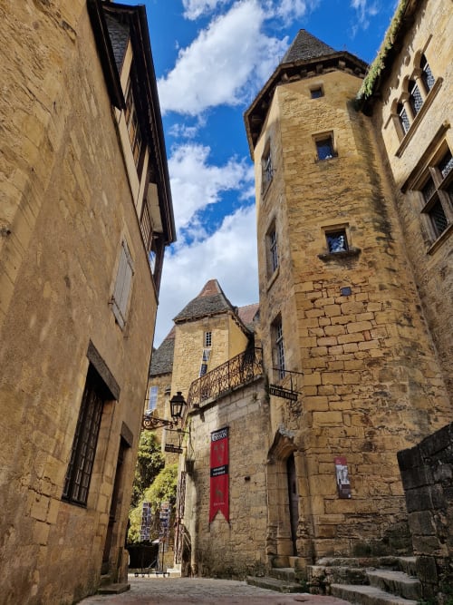 Tours médiévales en pierre et bâtiments historiques à Thénon, charmante rue pavée avec architecture authentique