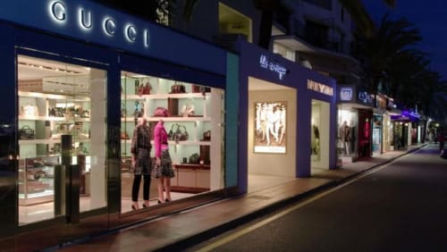 Elegante tienda Gucci en la exclusiva avenida comercial de Marbella por la noche, cerca de Puerto Banús