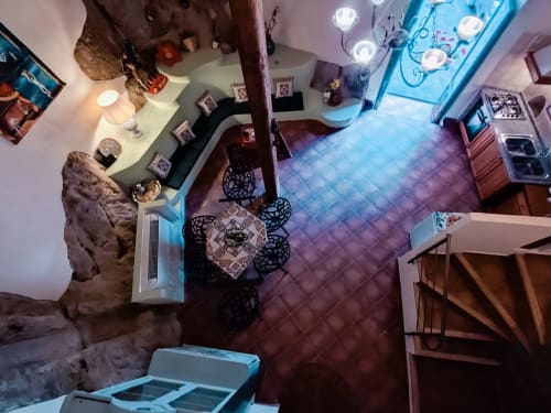 Zona pranzo di Casa Fiore del Borgo con illuminazione decorativa e elementi in pietra a Castiglione di Sicilia