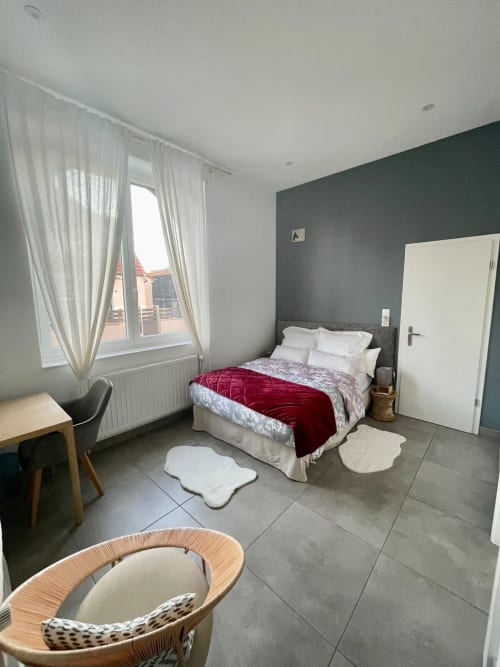 Chambre moderne à Illkirch-Graffenstaden avec mur d'accent vert, vue sur la ville et mobilier contemporain