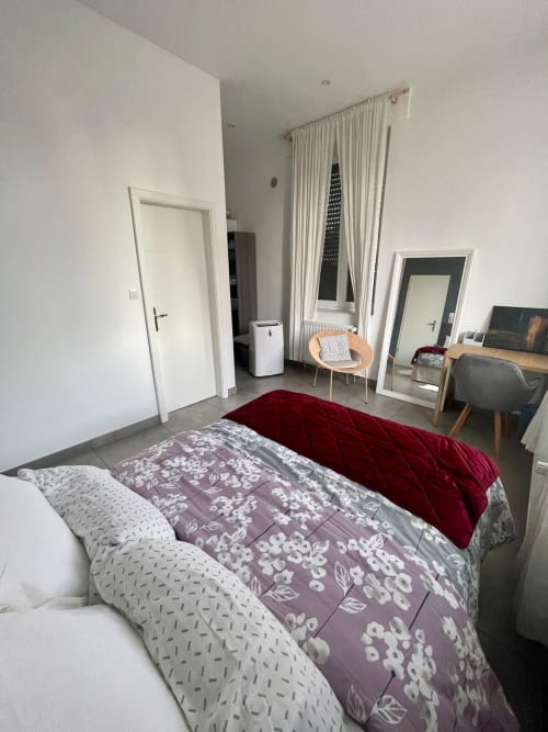 Chambre moderne à Illkirch-Graffenstaden avec vue sur la ville, lit, bureau, chaise et fenêtre avec rideaux