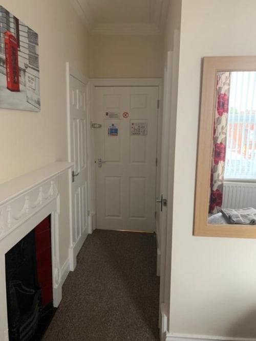 Hallway in The Ball Alley single room with white doors, cream walls, fire safety equipment, and mirror at Stanley B&B