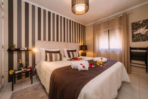Elegant double bedroom at Casa da Praia with striped accent wall, white linens, and beach house decor in Zambujeira do Mar