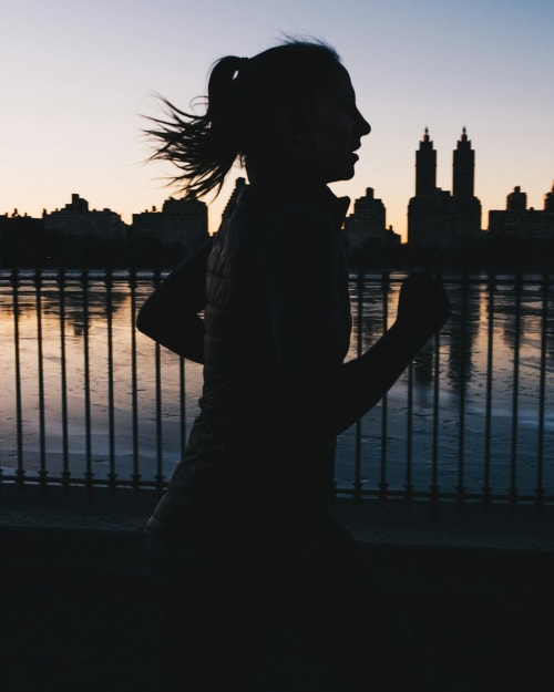 Woman jogging at sunset with city skyline, near The Ball Alley B&B in Stanley, County Durham
