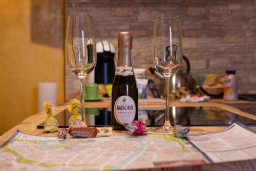Bottiglia di Prosecco Maschio con flûte di champagne e elementi decorativi nell'appartamento Dimore Verona