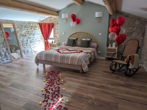 Chambre romantique du gîte La Romance à Bagard avec pétales de roses, ballons rouges et décoration cœurs