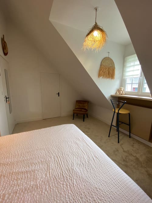 Chambre mansardée lumineuse aux Chambres d'hôtes Lady Jule avec lit blanc, luminaires suspendus en osier, bureau et fenêtre