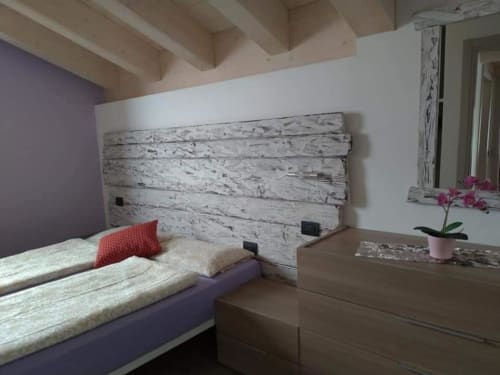 Camera da letto moderna all'Al Dos di Livigno con testata bianca, parete accent viola e vista sulle montagne
