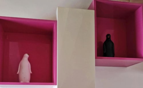Moderne scatole espositive rosa nell'appartamento Al Dos Livigno, una con pinguino bianco, l'altra con sagoma nera