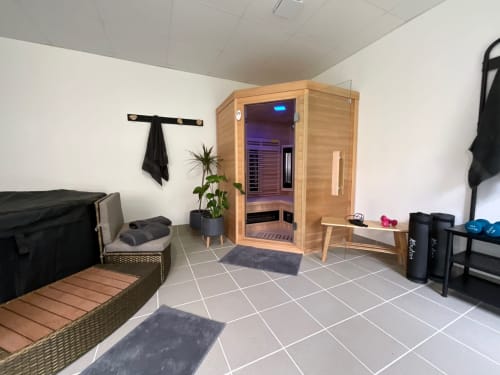 Spa room at Locacharme cottage in Blois with wooden sauna, relaxation seating, and fitness area