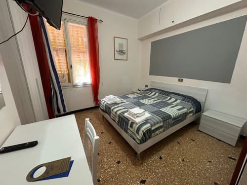 Camera da letto del Vecchie Mura B&B a Varazze con letto, scrivania e finestra con vista sul giardino