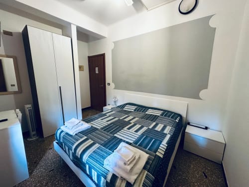 Camera moderna di Vecchie Mura B&B a Varazze con biancheria a righe, mobili bianchi e arredamento contemporaneo