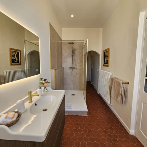 Salle de bain moderne à La Cordeline B&B à Brignoles avec douche à l'italienne, miroir lumineux et carrelage en terre cuite