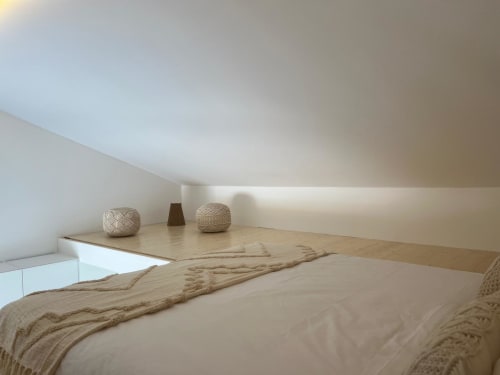 Quarto minimalista na villa Casa Ingrina, Bordeira, com cama de plataforma em madeira, tons neutros e objetos decorativos trançados