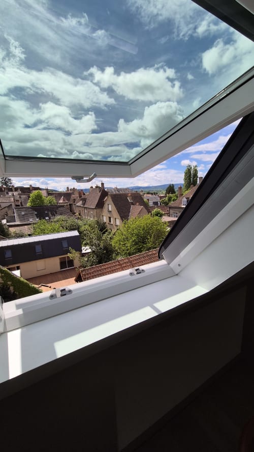 Panoramisch stadsaussicht vanuit appartement L'Arbre Voyageur bij Moulin Renaudiots in Autun, Frankrijk met dakraam over Europese architectuur